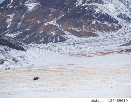 Snow ground mountain. Small figure of a riders. Snow ground mountain. Small figure of a riders. 124489610