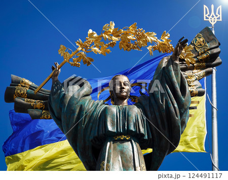 Kyiv, Ukraine July 20, 2020: A monument dedicated to the independence of Ukraine against the background of the largest Flag of Ukraine Kyiv, Ukraine July 20, 2020: A monument dedicated to the independence of Ukraine against the background of the largest Flag of Ukraine 124491117
