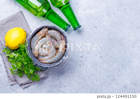Fresh raw shrimps, accompanied by sprigs of fresh parsley and juicy lemon Fresh raw shrimps, accompanied by sprigs of fresh parsley and juicy lemon 124491150