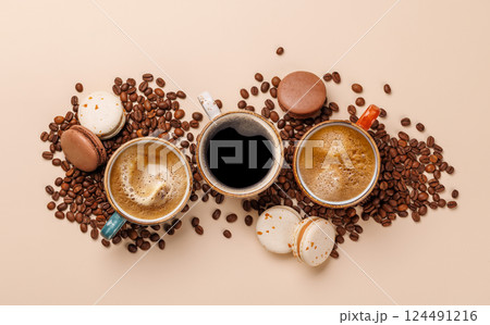 A steaming cups of freshly brewed coffee surrounded by rich, aromatic roasted coffee beans 124491216