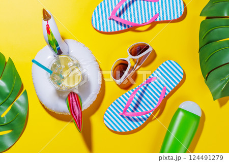 A vibrant summer vacation scene with flip flops, shades, and a floating flamingo 124491279