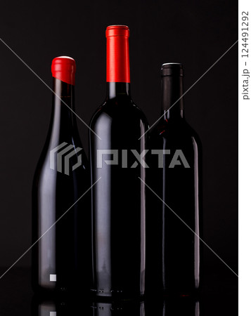 Elegant presentation of red wine bottles against a dark background 124491292