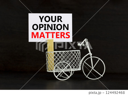 Your opinion matters symbol. Concept words Your opinion matters on beautiful white paper on clothespin. Beautiful black background. Miniature bicycle. Business your opinion matters concept Copy space 124492468