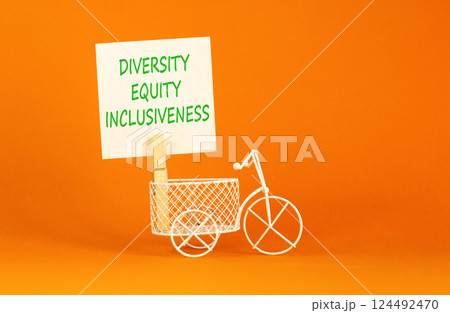 DEI diversity equity inclusiveness symbol. Concept words Diversity Equity Inclusiveness on white paper. Beautiful orange background. Business DEI diversity equity inclusiveness concept. Copy space. 124492470