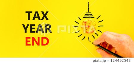 Tax year end symbol. Concept words Tax year end on beautiful yellow paper. Beautiful yellow background. Businessman hand. Light bulb icon. Business tax year end concept. Copy space. Tax year end symbol. Concept words Tax year end on beautiful yellow paper. Beautiful yellow background. Businessman hand. Light bulb icon. Business tax year end concept. Copy space. 124492542