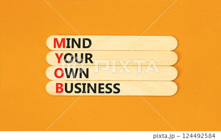 MYOB mind your own business symbol. Concept word MYOB Mind Your Own Business on beautiful wooden sticks. Beautiful orange background. Business MYOB mind your own business concept. Copy space. 124492584