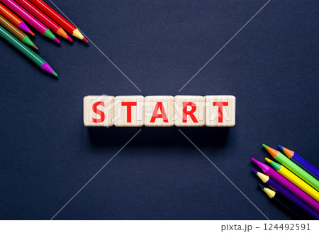 Start symbol. Concept word Start on beautiful wooden blocks. Beautiful black table black background. Beautiful colored pencils. Business lifestyle start concept. Copy space. 124492591