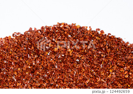 Crushed red hot chili pepper natural seasoning, white background, copy place for text, top view Crushed red hot chili pepper natural seasoning, white background, copy place for text, top view 124492659