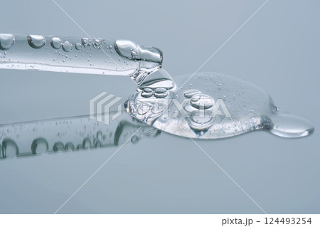 Pipette with serum on a blue background. Product texture. Pipette with serum on a blue background. Product texture. 124493254