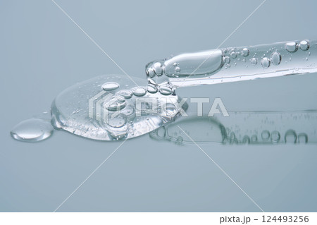 Pipette with serum on a blue background. Product texture. Pipette with serum on a blue background. Product texture. 124493256