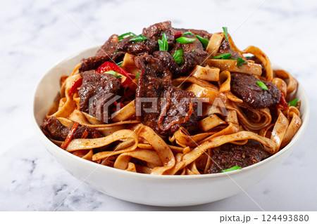 Udon noodles with Mongolian beef, green onions and vegetables, in a white plate, on a light background, homemade, no people, Udon noodles with Mongolian beef, green onions and vegetables, in a white plate, on a light background, homemade, no people, 124493880