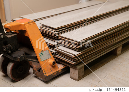 Stack of used laminate flooring planks on a pallet. Reclaimed wood material for renovation, recycling, or construction projects. 124494821