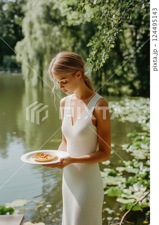 A woman is holding a plate with a pie on it 124495143