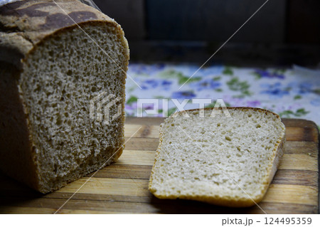 Rustic sourdough bread with cut slices on a wooden table on black background with free space Rustic sourdough bread with cut slices on a wooden table on black background with free space 124495359