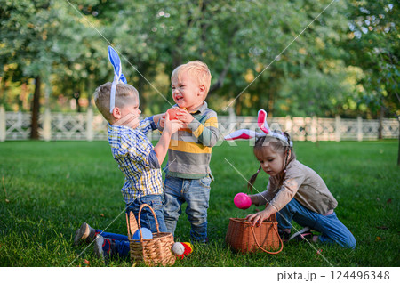 Children Playing and Sharing Easter Eggs During Outdoor Hunt 124496348