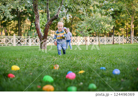 Children Hunting Easter Eggs in the Garden with Bunny Ears Children Hunting Easter Eggs in the Garden with Bunny Ears 124496369