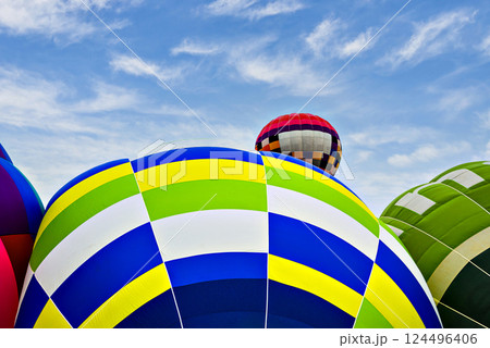 Colorful hot air balloon flying over blue sky with white clouds 124496406