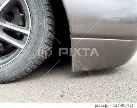 Close up photo of car front bumper clearance, very low suspension on vehicle with cool style. Modified car with bottom down on asphalt for cool look. Lowered car culture. Car is lying on the ground 124496412