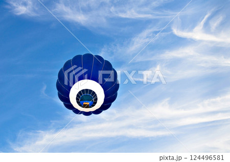 Blue hot air balloon flying on the blue sky with white clouds 124496581