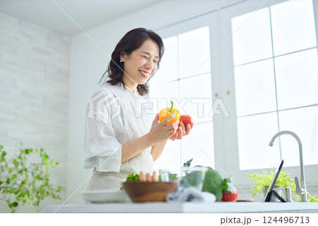 タブレットでレシピを見ながら料理をするミドル女性 124496713