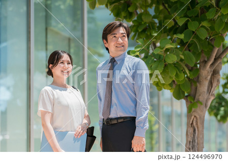 オフィス街にいるスーツ姿のビジネスマン男女 オフィス街にいるスーツ姿のビジネスマン男女 124496970