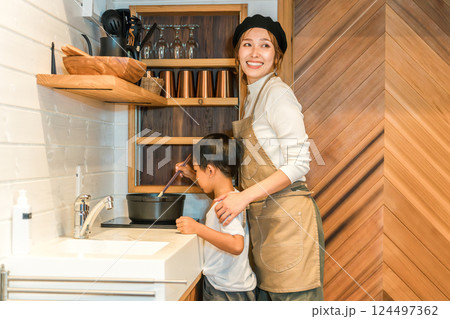 キッチンでお母さんと一緒に料理する男の子 124497362