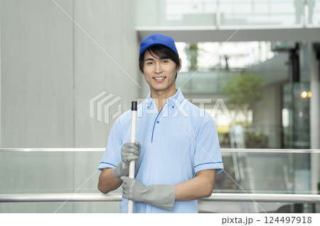 カメラ目線で笑顔の若い男性クリーニングスタッフ 124497918