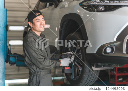 リフトアップした車のタイヤを脱着する整備士の男性（タイヤ交換） 124498098