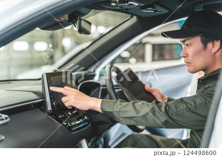 自動車の車内でタブレット端末を使う自動車整備士の男性 124498600