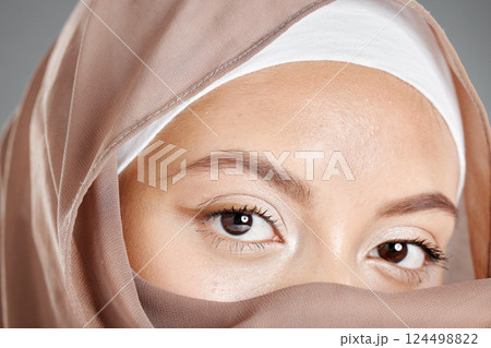 Muslim, eye and beauty with face of woman for health lashes, makeup and vision in grey background. Youth, cosmetics and skincare with islamic girl and zoom in stare for hijab, serious or religion Muslim, eye and beauty with face of woman for health lashes, makeup and vision in grey background. Youth, cosmetics and skincare with islamic girl and zoom in stare for hijab, serious or religion 124498822