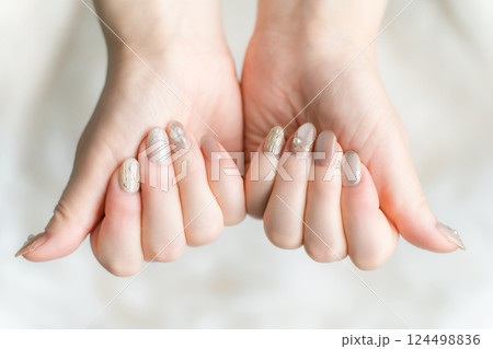ネイルサロンでネイルをした手（マグネットジェル・ミラーライン） 124498836