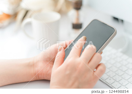 スマホ・スマートフォンの画面をタッチするネイルをした女性 スマホ・スマートフォンの画面をタッチするネイルをした女性 124498854
