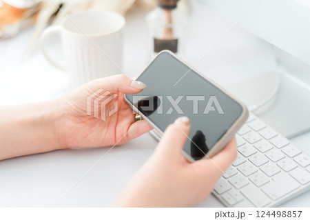 スマホ・スマートフォンの横向きの画面を見るネイルをした女性 124498857