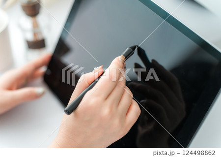 タブレットPCにペンタブを使って何かを描く女性(漫画家・クリエイター・デザイナー・アニメーター) 124498862