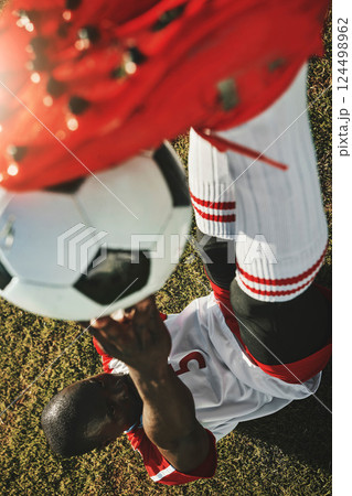 Above, soccer player and ball training, outdoor and on field for match, doing warm up and workout for health. Exercise, football and healthy athlete with ball, doing fitness and prepare for game. 124498962