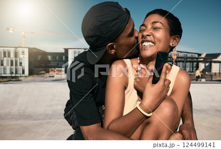 Couple, hug and kiss while bonding in city with phone for social media and internet search for fun Brazilian activity. Smile, happy and love man and black woman with 5g mobile technology and fashion 124499141