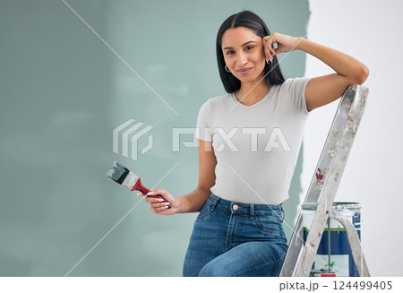 Wall, portrait and woman painting home with smile resting on ladder for balance with mockup. Renovation, improvement and young home owner girl holding paintbrush for green paint container. 124499405