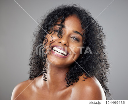 Black woman, beauty and hair in face, makeup or smile against studio background with happiness. Model, hair care and happy with cosmetics for skincare, self care or portrait with glow, skin or curly 124499486