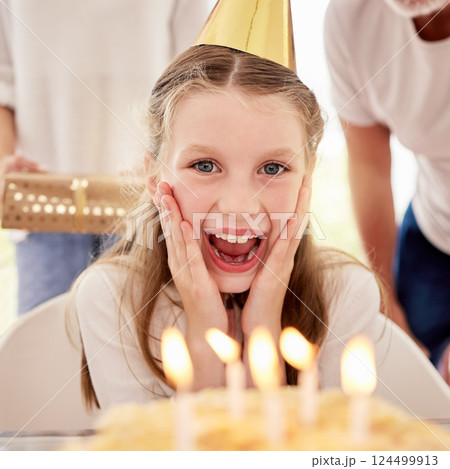 Happy, girl and birthday surprise by candles in celebration, happiness and wow facial expression at home. Portrait of female teenager celebrating special day with family by cake with smile for wish Happy, girl and birthday surprise by candles in celebration, happiness and wow facial expression at home. Portrait of female teenager celebrating special day with family by cake with smile for wish 124499913