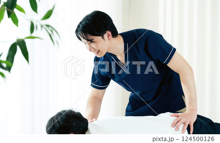 施術をする整体師の男性 施術をする整体師の男性 124500126