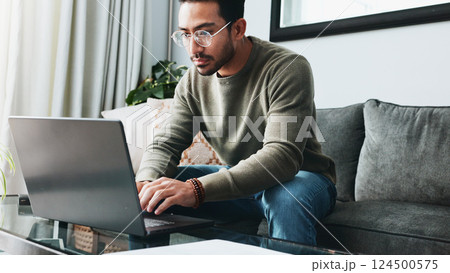 Glasses, reading and laptop with man on sofa for freelancer, business research and email. Communication, typing and online with person in living room at home for remote worker, networking and blog 124500575