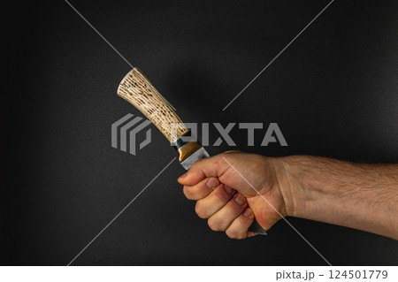 Hand holding a knife with a distinct handle 124501779