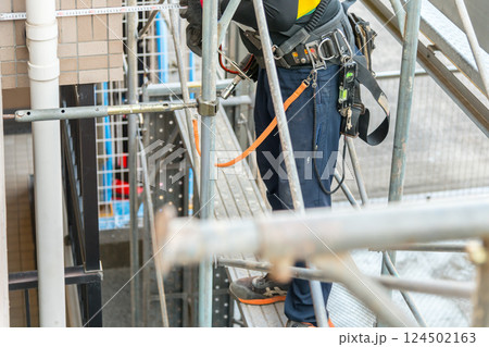 【マンション大規模修繕工事　壁つなぎを接続し足場を作る作業員】 124502163