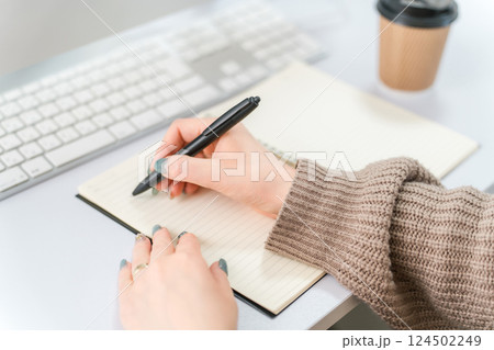 何かをメモする・書く女性(勉強・仕事・作家・ライター・日記・手帳・ネイル) 124502249