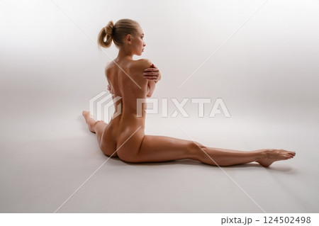 Elegant topless woman poses gracefully in a serene studio setting 124502498