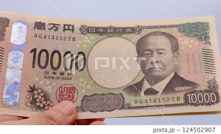 新一万円札を持つ人物のクローズアップ 124502907