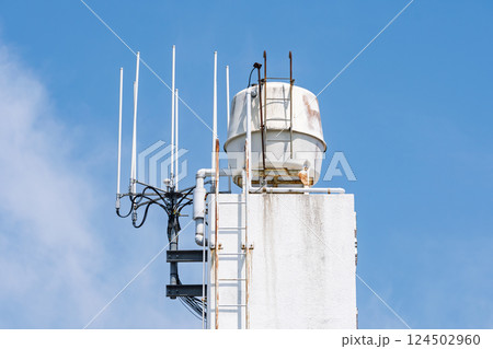 青空に映える貯水タンクとアンテナ 124502960