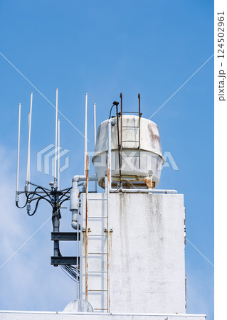 青空に映える貯水タンクとアンテナ 124502961