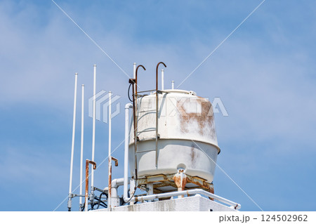 青空に映える貯水タンクとアンテナ 124502962