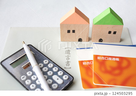 遺言状と残されたマイホームや通帳や札束と電卓と印鑑 124503295